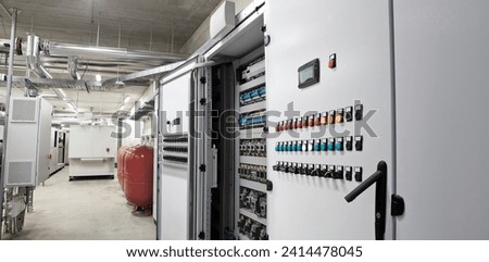 Electrical panel cabinet for HVAC system control, managing heating, ventilation, air conditioning, and cooling. Climate control system, including the boiler room, ensures comfort of the rooms building Royalty-Free Stock Photo #2414478045