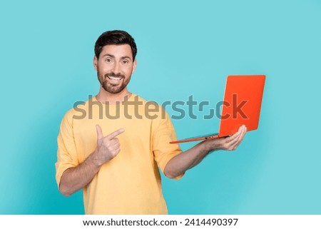 Photo of young guy introduce his new apple macbook pro recommend buy this gadget on amazon website isolated over cyan color background