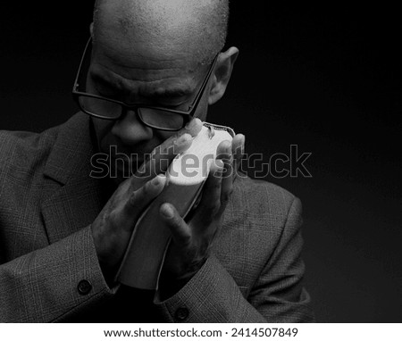 man praying to god Caribbean man praying with black grey background with people stock image stock photo	
