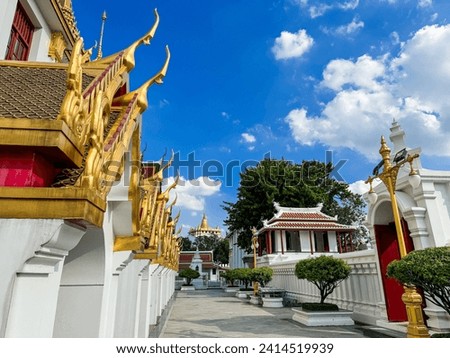 A picture of a Thai temple in bright brass color overlooking the Golden Mountain of Wat Saket.