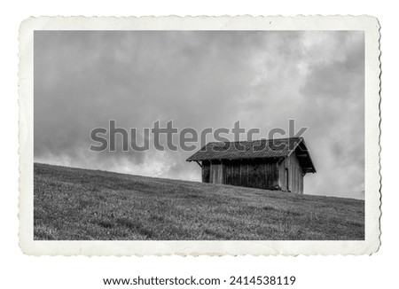 Old nostalgic picture postcard in black and white showing a wooden farmhouse on a meadow in alpe di siusi, south tyrol, Italy