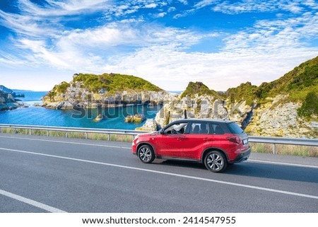 Red car drive on the road of mediterranean beach. driving on coast of France. Highway view on coast on way to summer holiday. Europe travel trip in sea coast road landscape. holiday journey on nature Royalty-Free Stock Photo #2414547955