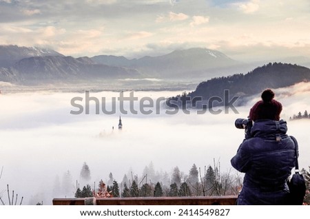 photographer woman taking pictures of amazing sunrise at lake Bled from Ojstrica viewpoint, Slovenia, Europe - travel background