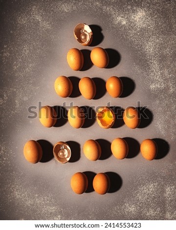 The eggs are laid out in the shape of a Christmas tree. Two eggs are broken. New Year's picture