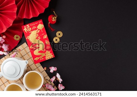Discovering the traditions of the chinese New Year tea ritual. Top view photo of tea crockery, money envelope, traditional chinese decor on black background with promo space