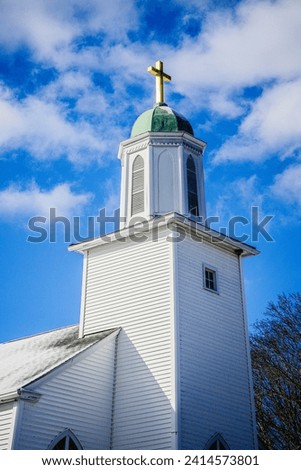 Chapel with golden cross and the blue sky with white clouds, close-up