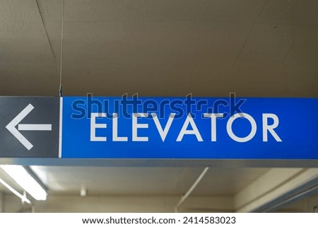 Elevator sign with an arrow in a parking garage