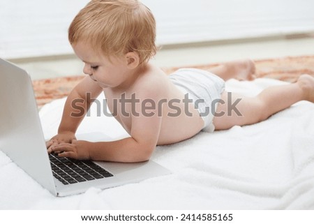 Baby, playing and learning on laptop in home on bed with online games for education. Child, typing and relax with cartoon, movies or development of knowledge of technology with elearning for growth