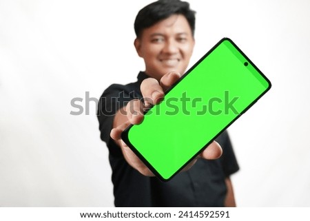 A man is showing the contents of his cellphone screen with a green screen display at a diagonal angle.
