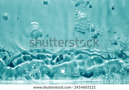 Blue splashing cosmetic moisturizer, micellar water,  toner, or emulsion abstract background. Transpatent texture with bubbles Royalty-Free Stock Photo #2414603121