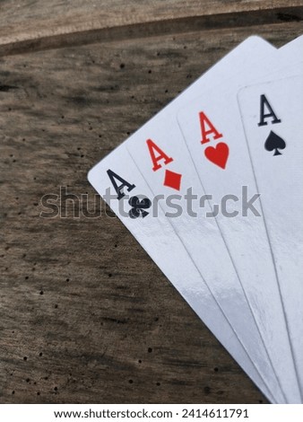Four A cards on a weathered wooden background