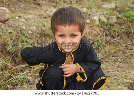 A Pakistani 3 year old girl wearing Pakistani cultural dress and posing against cotton farms. Pakistani baby girl. Punjab Pakistan. Asian girl in farm. Pakistani kids. With selective focus on subject.