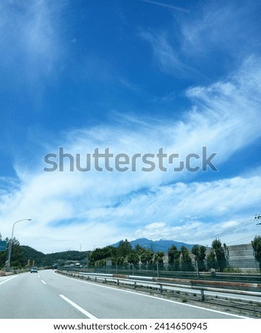 take. on road with blue skies and mountains in the background.