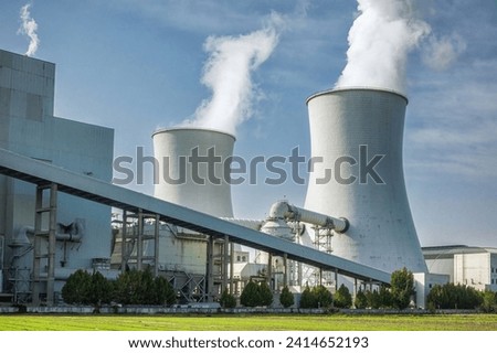 Industrial Cooling Towers Emitting Steam at Power Plant Royalty-Free Stock Photo #2414652193