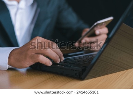 Close up shot Businessman working on laptop, fingers on desk, familiar with work and goals.