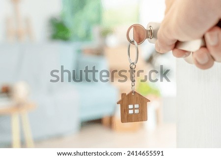 Moving house, relocation. The key was inserted into the door of the new house, inside the room was a cardboard box containing personal belongings and furniture. move in the apartment, banner Royalty-Free Stock Photo #2414655591