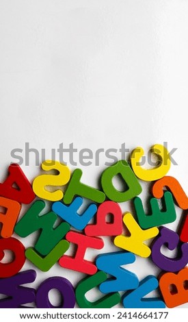 English Alphabet On A White Background. alphabets on a wooden surface. xyz - letters. scattered mixed colorful wooden letters of the English alphabet on backdrop, copy space,  background composition
