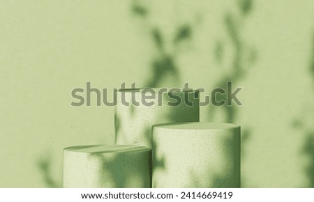 Minty chic: Trio of cylindrical platforms in soft mint green. Gentle shadows and playful light create an inviting ambiance, perfect for contemporary product displays. Royalty-Free Stock Photo #2414669419