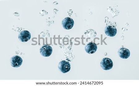 Blueberries falling into water close up detail