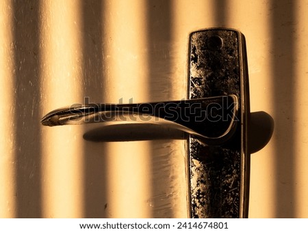 A close up picture of a vintage door lock in a shady brown background. 