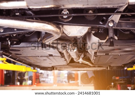 Close-up of catalytic converter in automobile exhaust system. Royalty-Free Stock Photo #2414681001