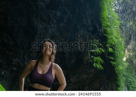 Young  woman in sportswear standing in a nature scenery, looking at the camera and smiling, Bali