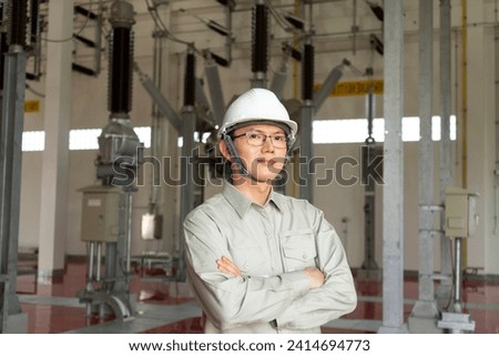 Engineers technicians man wearing professional helmets working in powerhouse or power plant. Royalty-Free Stock Photo #2414694773