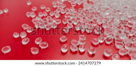 Virgin plastic material granules isolated on a red background for industrial plastic company product catalog design