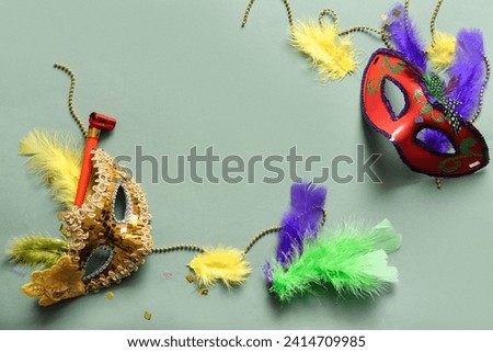 Carnival masks with party horn and decor for Mardi Gras celebration on green background