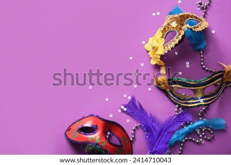 Carnival masks with feathers and beads for Mardi Gras celebration on purple background