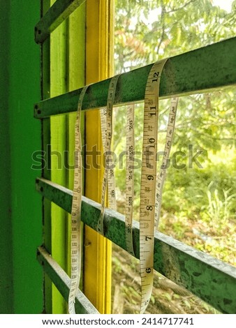 a tailor's measuring tape hanging above the glass window