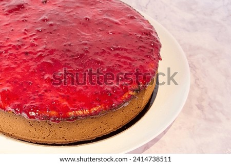 Close up of a strawberry cheesecake on a white plate with copy space