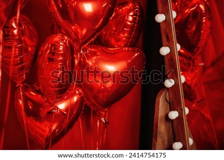 Extravagant glamour background with red foil heart air balloons for love party. Beautiful romantic burlesque room place for st valentines holiday illuminated vanity makeup mirror muffled light Royalty-Free Stock Photo #2414754175