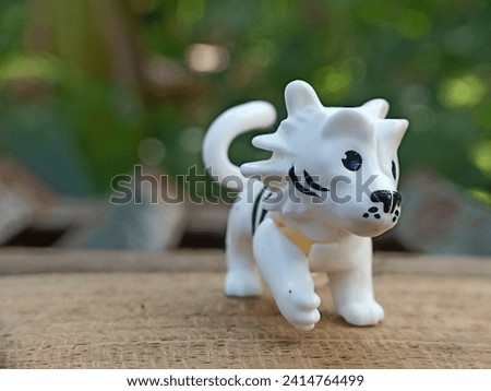 A toy shaped like a white dog. Macro photo of white dog toy.