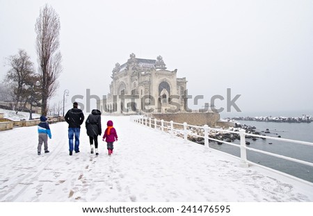 Snowing on the shore at the Black Sea, in Constanta, Romania. Casino building is at the background.