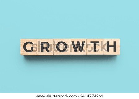 growth wooden cubes on blue background Royalty-Free Stock Photo #2414774261
