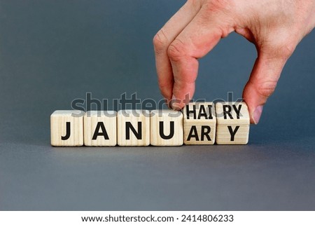 Januhairy or January symbol. Concept words Januhairy or January on beautiful wooden blocks. Beautiful grey table grey background. Man hand. Social issues Januhairy or January concept. Copy space.