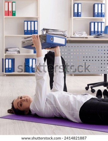 Female employee doing sport exercises in the office