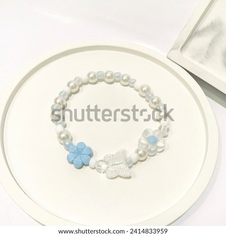 Bracelet with pearl beads, flower and butterfly beads. Cute beaded bracelet for women. This picture is good for ads or online store catalogue. Accessories modern fashion design. Jewelry handmade