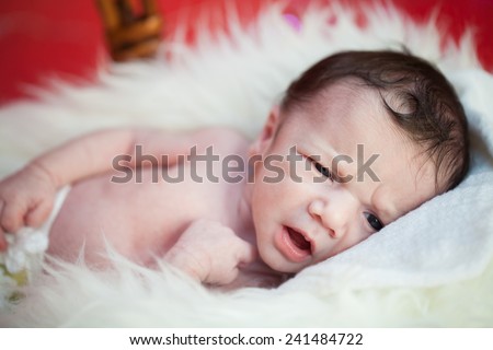 picture of a newborn baby curled up sleeping on a blanket 