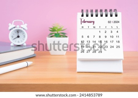 February Mini desk calendar for 2024 year on worktable with pink background.