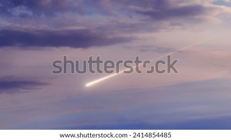 Meteor in the sky in the light of the sun. A meteorite falls in the daytime. Bright fireball at sunset.