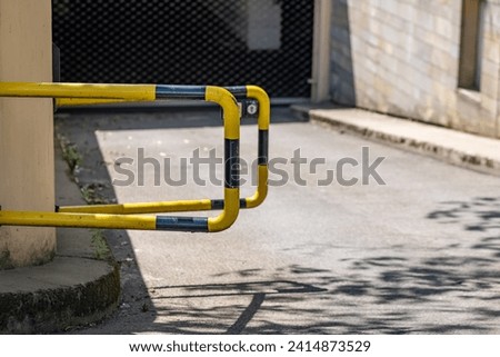 a black and yellow security barrier in front of a parking garage