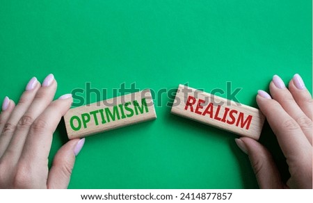 Optimism or Realism symbol. Concept word Optimism or Realism on wooden blocks. Businessman hand. Beautiful green background. Business and Optimism or Realism concept. Copy space