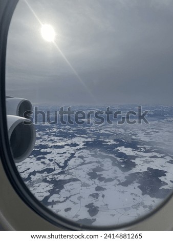 Airplane picture from window flying over the snowy alps
