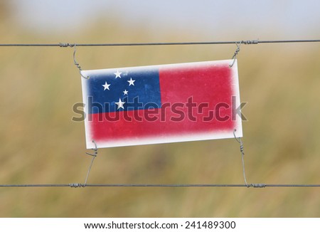 Border fence - Old plastic sign with a flag - Samoa