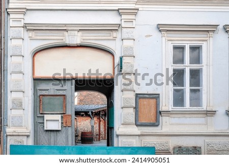 Baroque-style outdoor entrance with blank boards to a winery, restaurant, and shop in the historical downtown with Baroque architecture