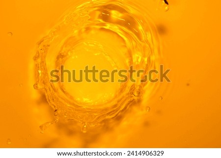 Orange water crown caused by water droplets falling on the surface, orange light splashing on transparent skin, air bubbles splashing, fresh and natural. Royalty-Free Stock Photo #2414906329