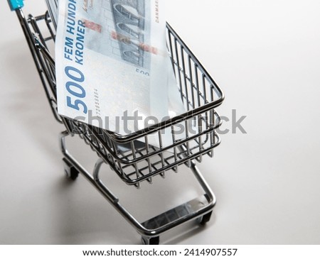 Money of Denmark. Danish kroner bills and supermarket shopping cart. DKK banknotes. 500 kroner. Business, finance, news background. High quality photo