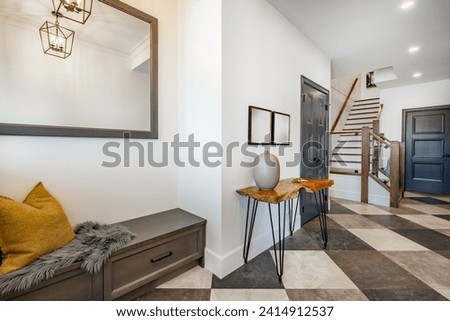 Welcoming entry interior with large wooden and glass doors hardwood and tile floors staircase Royalty-Free Stock Photo #2414912537